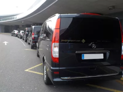 Van Mercedes noir en file de dépose-minute pour service de chauffeur privé