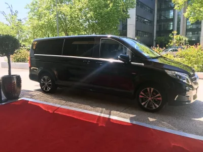 Van noir haut de gamme stationné près d’un tapis rouge pour accueil VIP