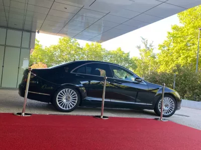 Berline Mercedes noire sur tapis rouge devant un bâtiment pour prestation chauffeur VIP