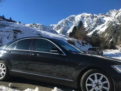 Berline Mercedes noire en montagne enneigée, transport privé premium en hiver